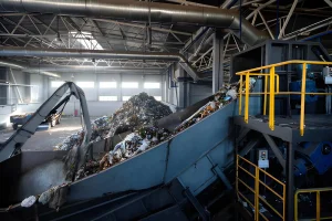 Fasilitas pengolahan sampah modern dengan conveyor belt dan mesin pemilah otomatis yang mengelola limbah padat di dalam pabrik daur ulang