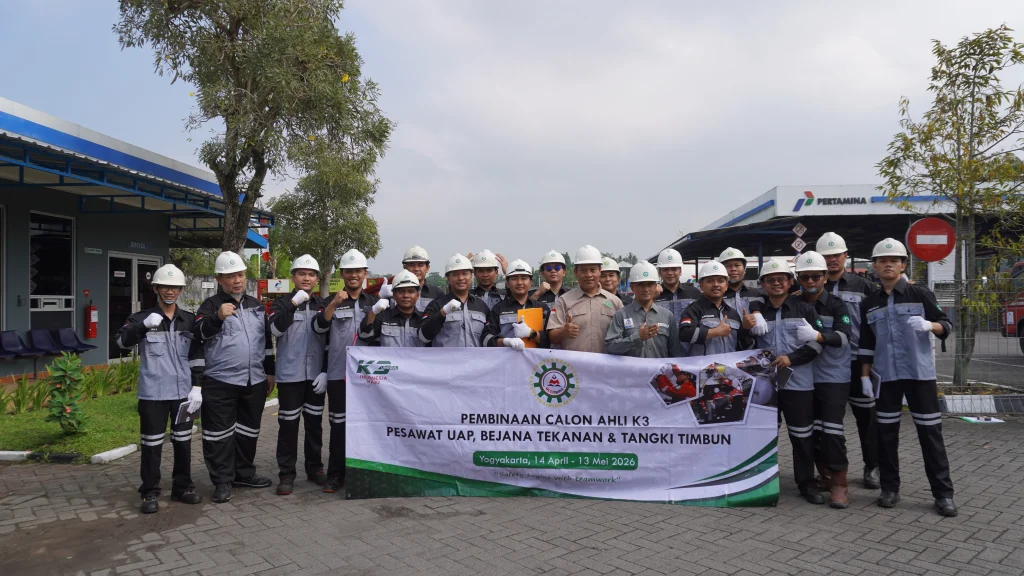 Peserta praktek kerja lapangan ahli k3 pubt melakukan foto bersama di area fasilitas industri SPBE dengan menggunakan APD lengkap dalam program pembinaan calon Ahli K3 Pesawat Uap, Bejana Tekanan, dan Tangki Timbun (PUBT).